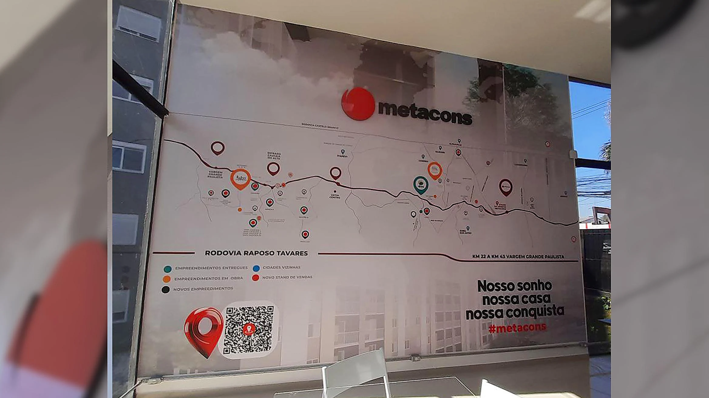 Vidro corporativo com adesivo personalizado mostrando mapa de empreendimentos da construtora Metacons